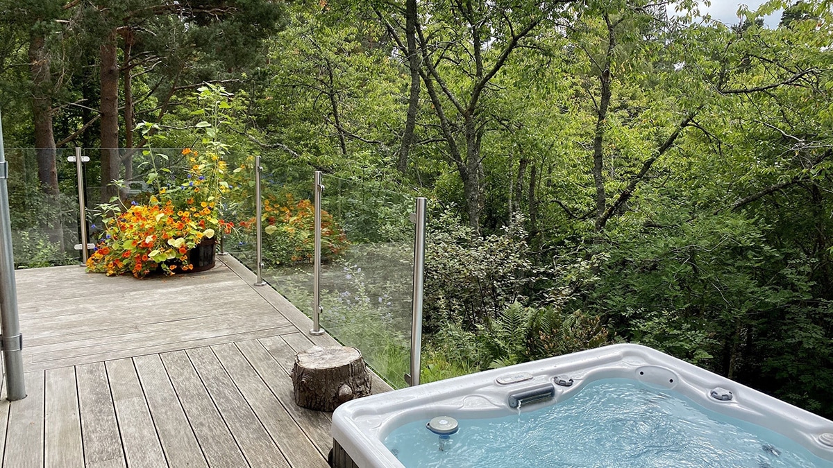 hot tub on deck surrounded by trees An Cala Nethy Bridge