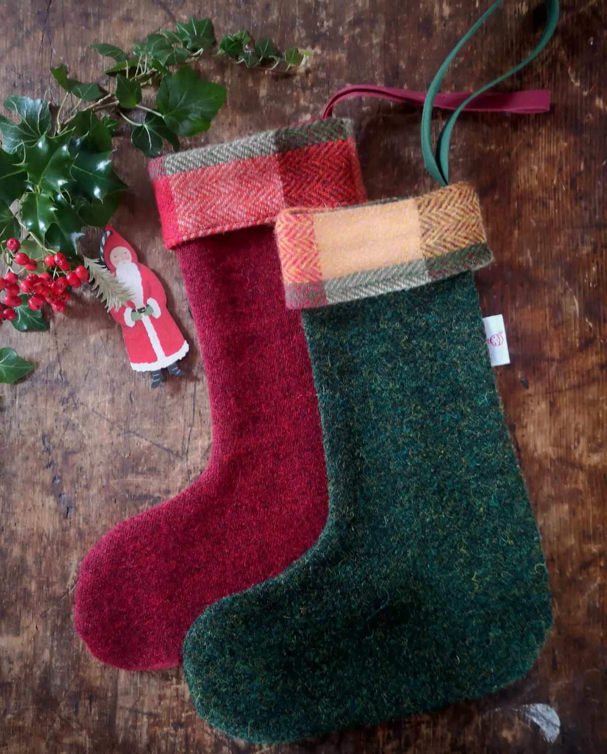 A green Harris tweed stocking laid over a red tweed stocking