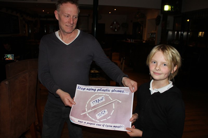 An Ullapool schoolchild with a poster promoting the #NaeStrawAtAw campaign