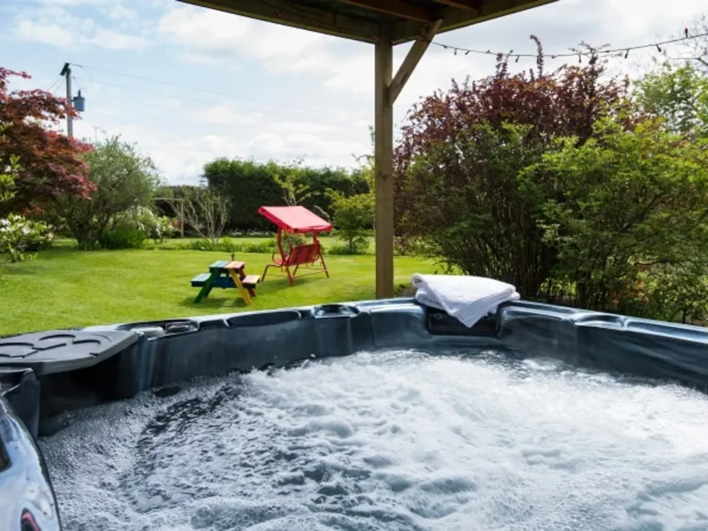 Strone House hot tub on green lawn in the sun