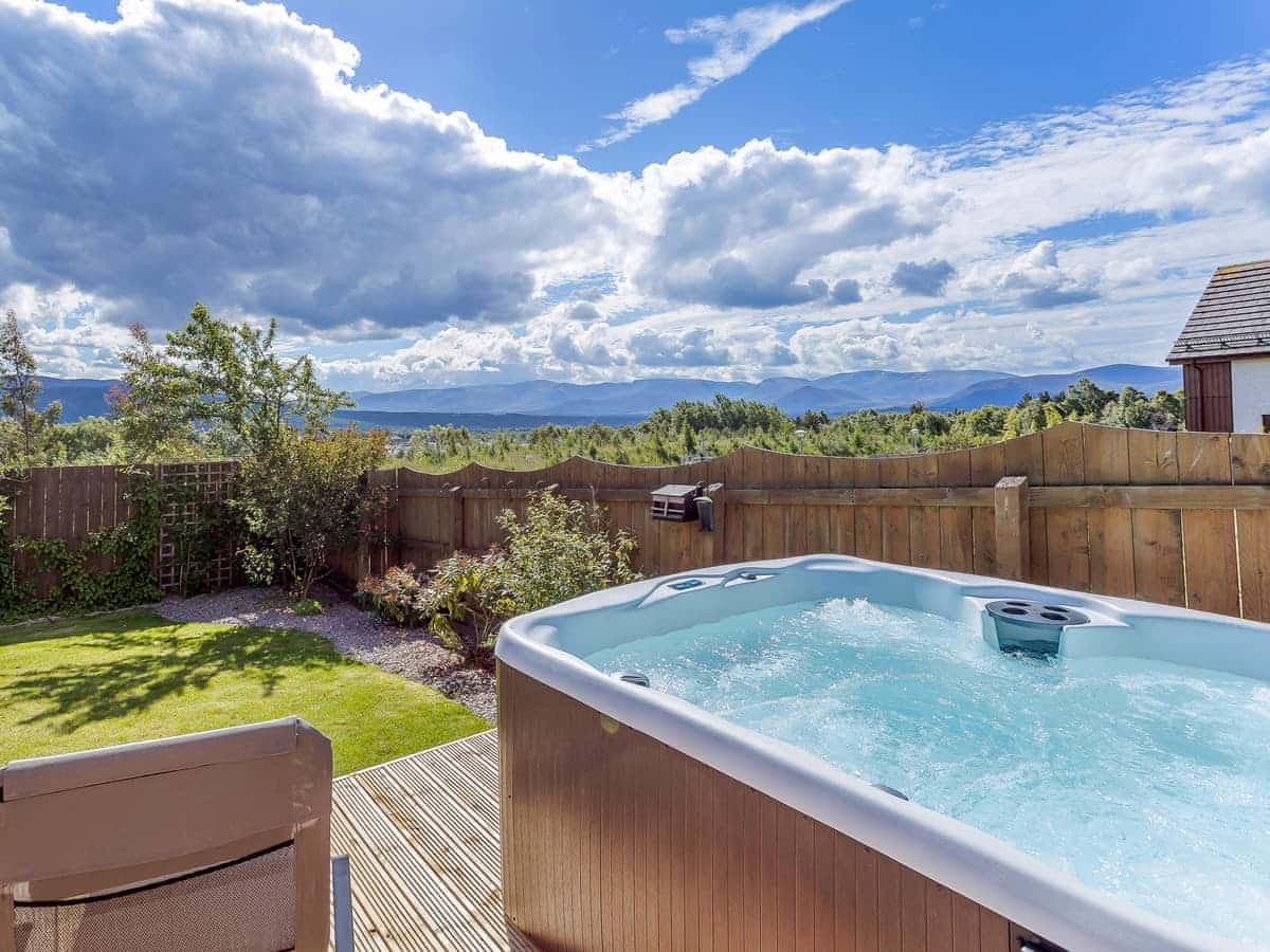 The Lookout Aviemore - hot tub in garden with mountain backdrop