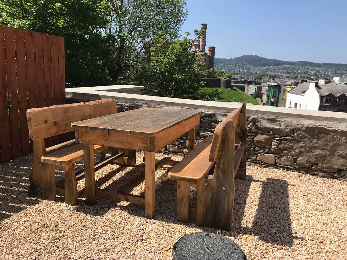bench and table on gravel garden with views of mountains